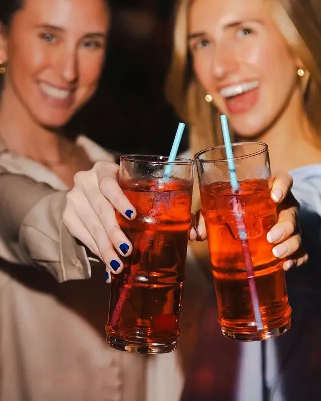 2 women with drinks in their hands at Puttshack