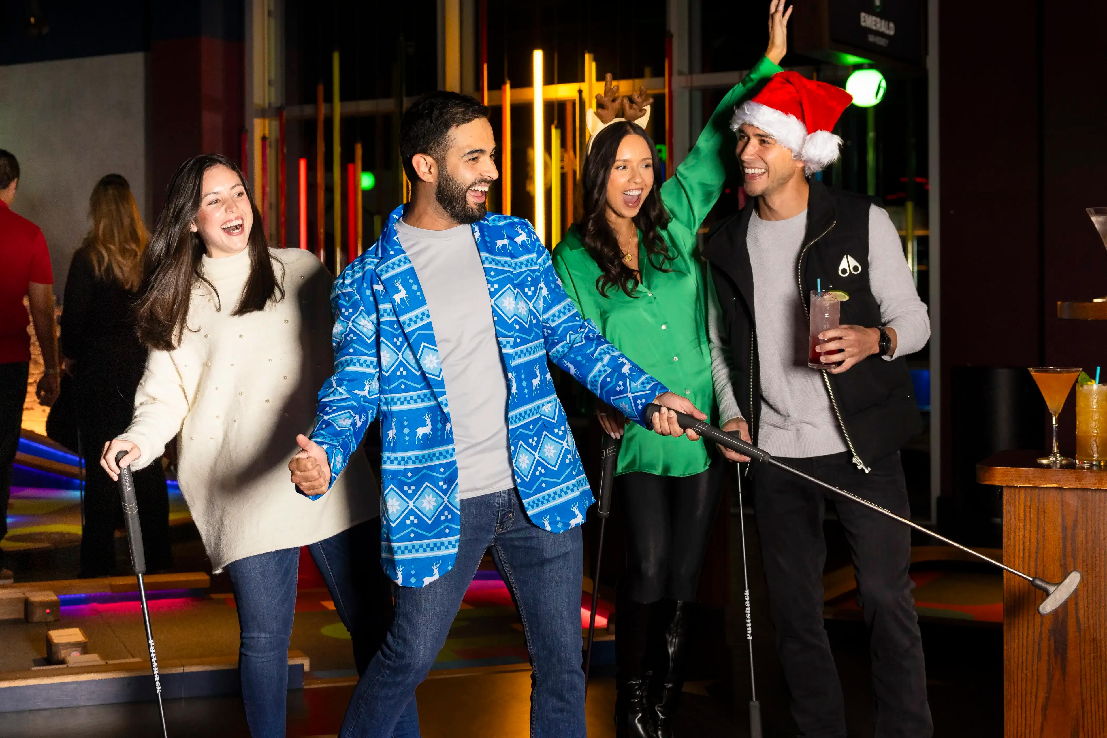 four guests celebrating a shot with holiday clothing